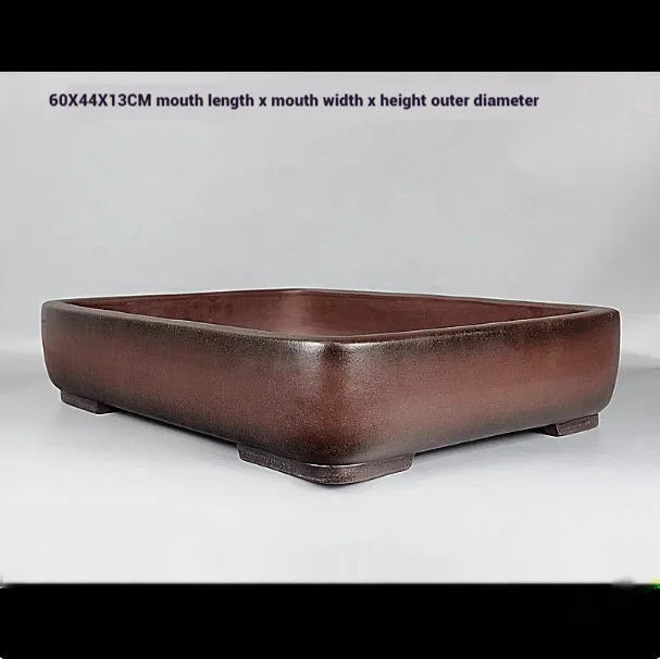 Handmade antique rectangular purple clay flower pot on tabletop