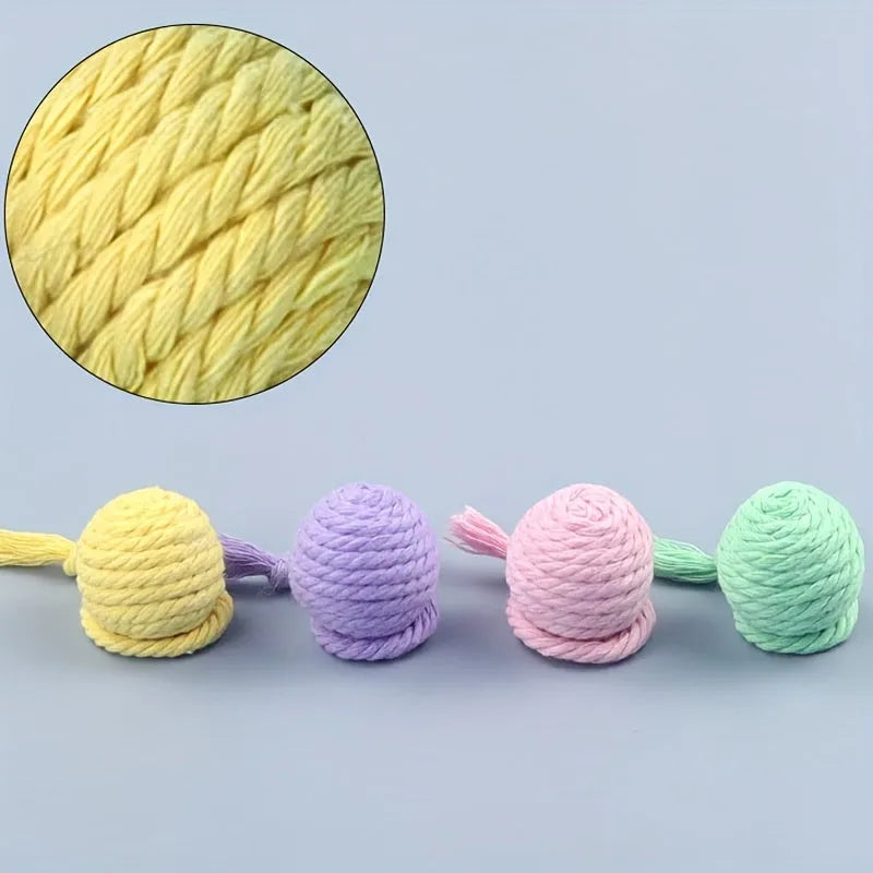 Coloured cat toy ball with rope attached and built-in bell inside, shown in green, pink, purple, and yellow options