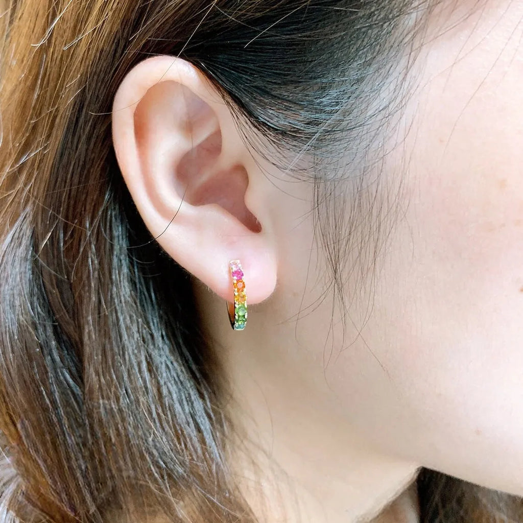 Copper U-shaped ear cuff with round zircon inlay in gold finish on earlobe
