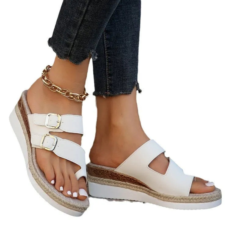 White patent leather wedge sandals with woven finger fit design and peep toe on a rubber sole.