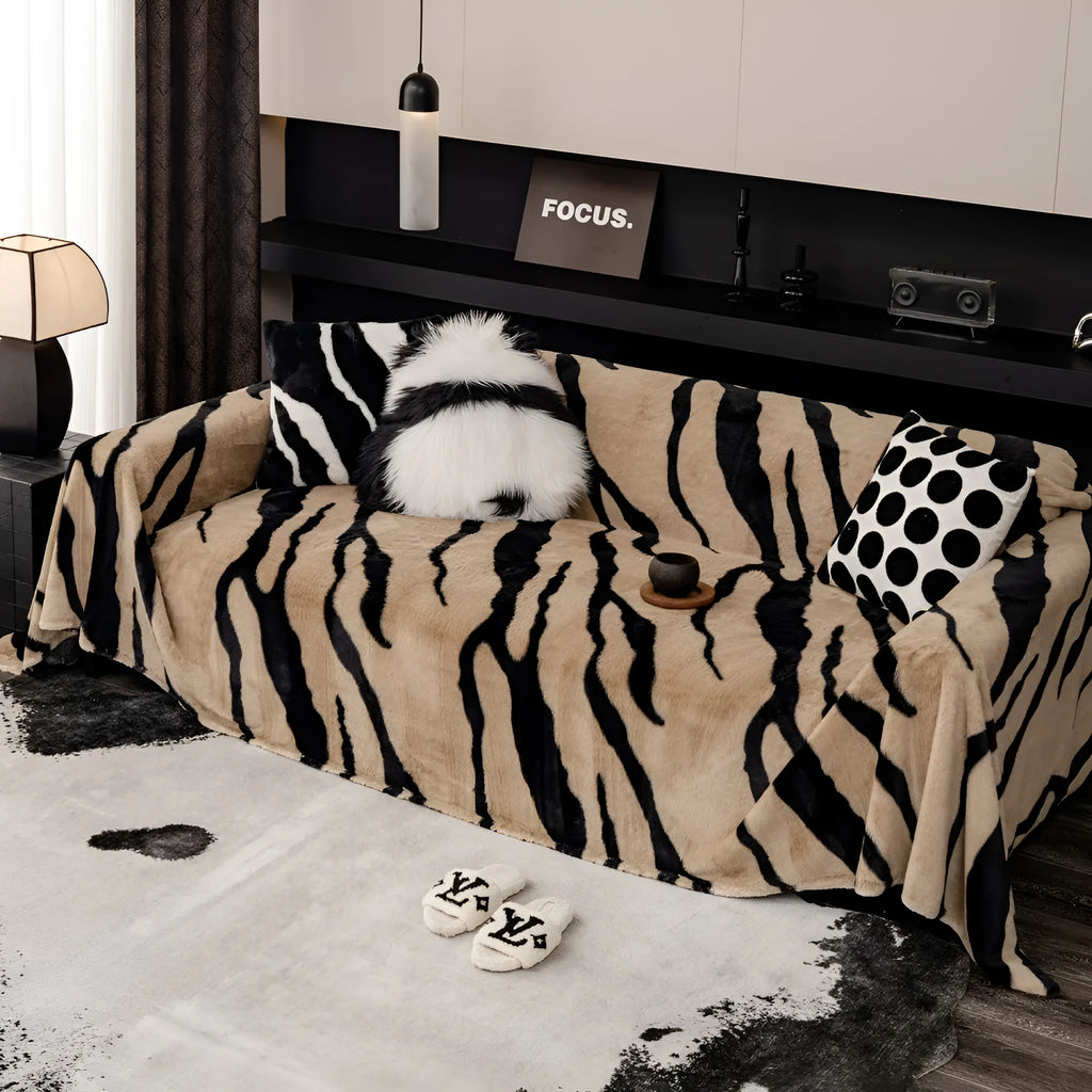 Thickened flannel zebra pattern sofa cover in caramel or black draping over a sofa with non-slip texture visible
