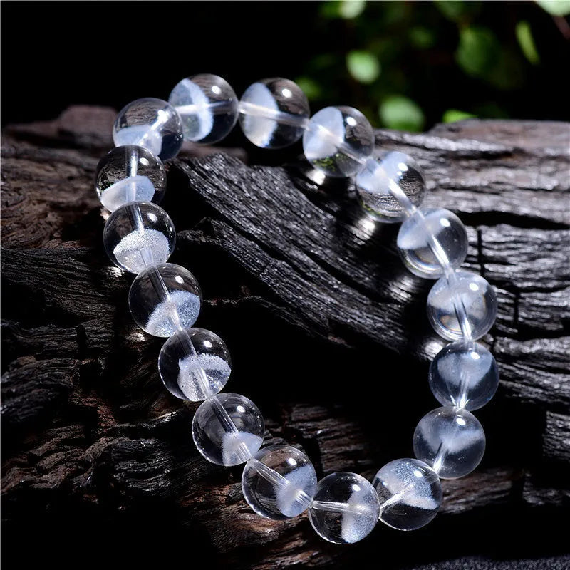 Women's white crystal ghost pyramid bracelet with Ruyi symbol on wrist, showing bead detail.