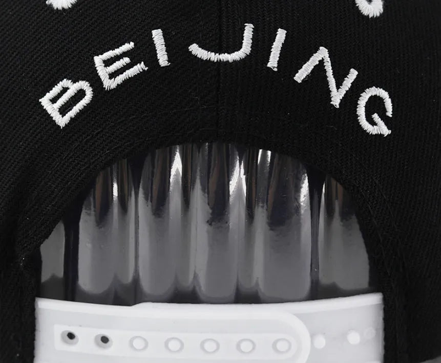 Unisex cotton baseball cap with letter embroidery available in black and white featuring adjustable dome crown design