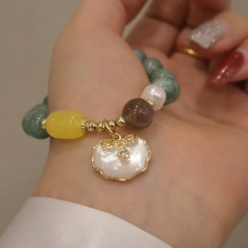 Green jade bracelet with carved shell charm and adjustable silver-tone clasp