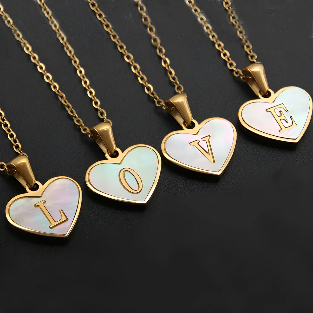 Gold-plated heart necklace with white shell pendant personalised with a letter, on an adjustable chain.