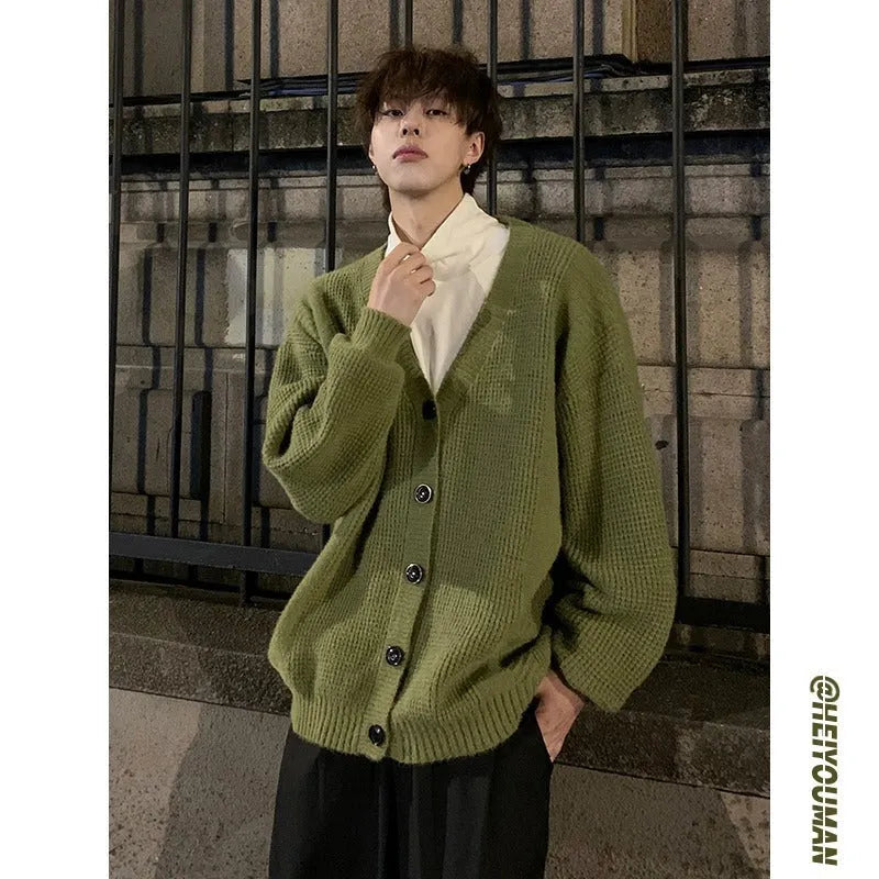 Men's loose fit V-neck knitted cardigan sweater in a solid colour on a hanger.