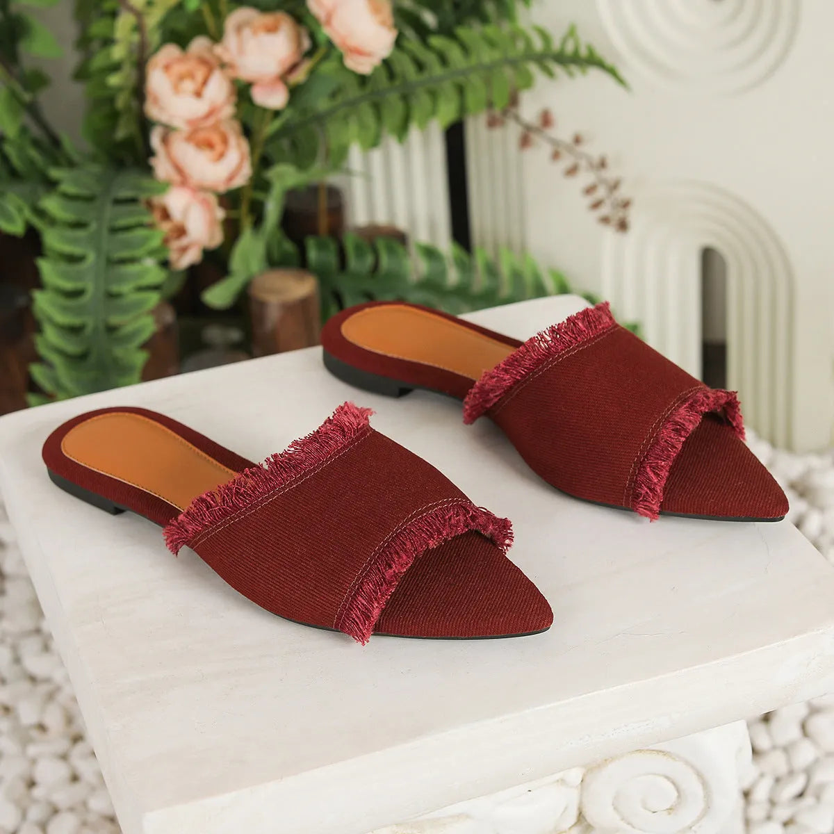 Women's denim flat slippers with tassel detail and leather lining in multiple colours.