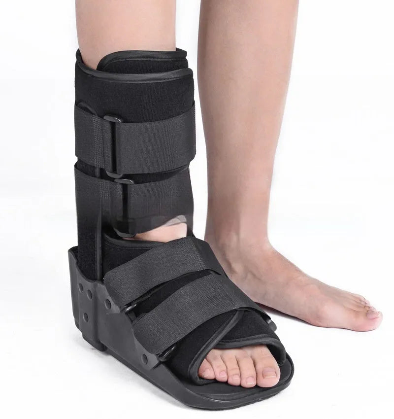 Grey Achilles tendon rehabilitation boot with aluminium side struts and a rubber sole, shown on a foot.