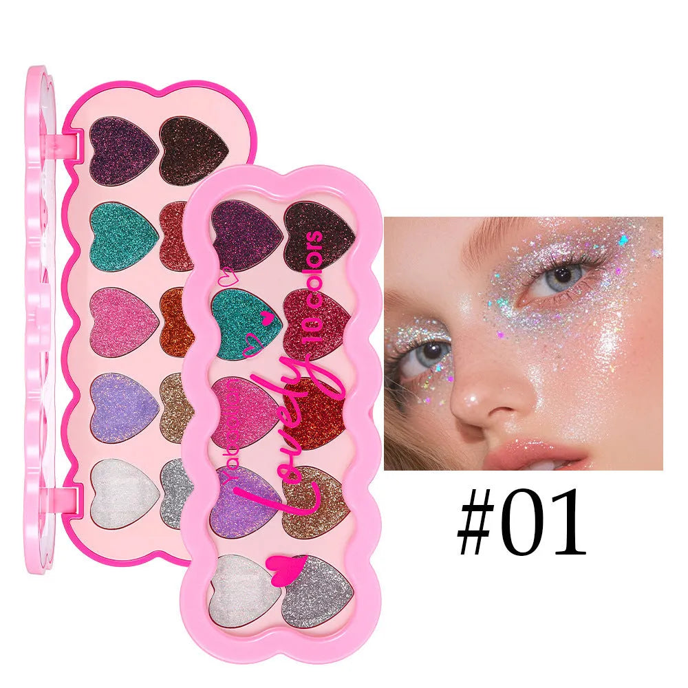 Heart-shaped case open to show ten eyeshadow pans in white, beige, pink, purple, brown, blue, black, royal blue, maroon, and coral.