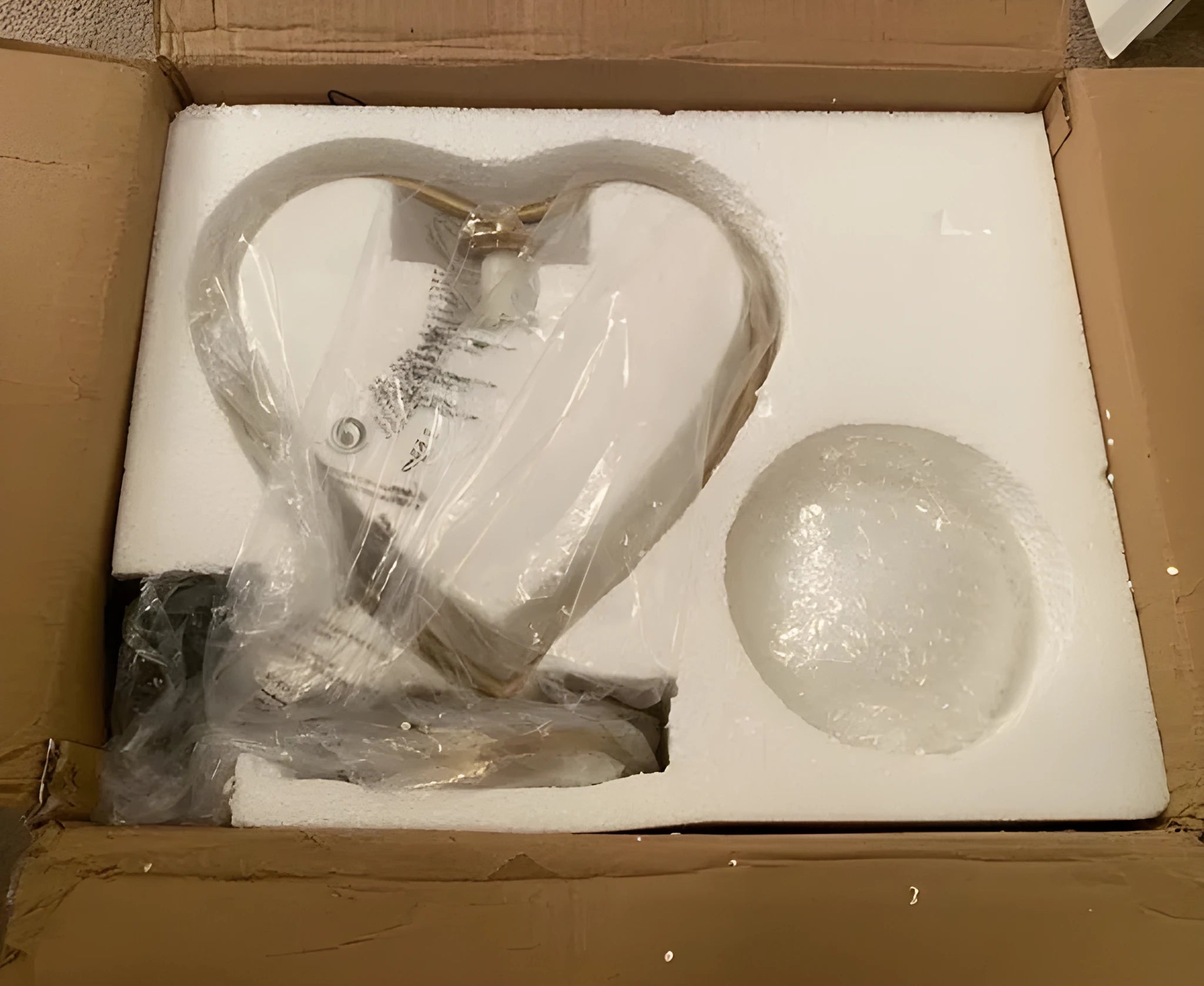 White heart shaped table lamp with a flexible metal arm and warm LED light on a wooden surface.
