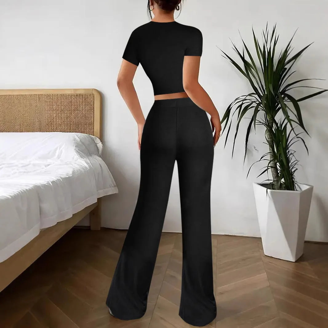 Black high-waist trousers and matching short-sleeve T-shirt co-ord set laid flat.