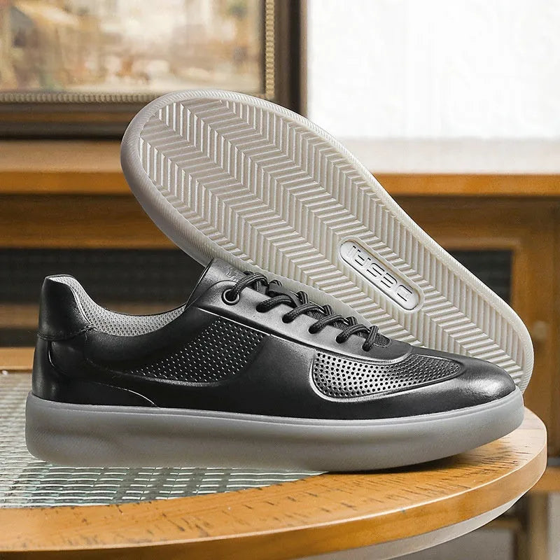 white perforated leather casual training shoes with rubber sole and front lace-up on flat surface