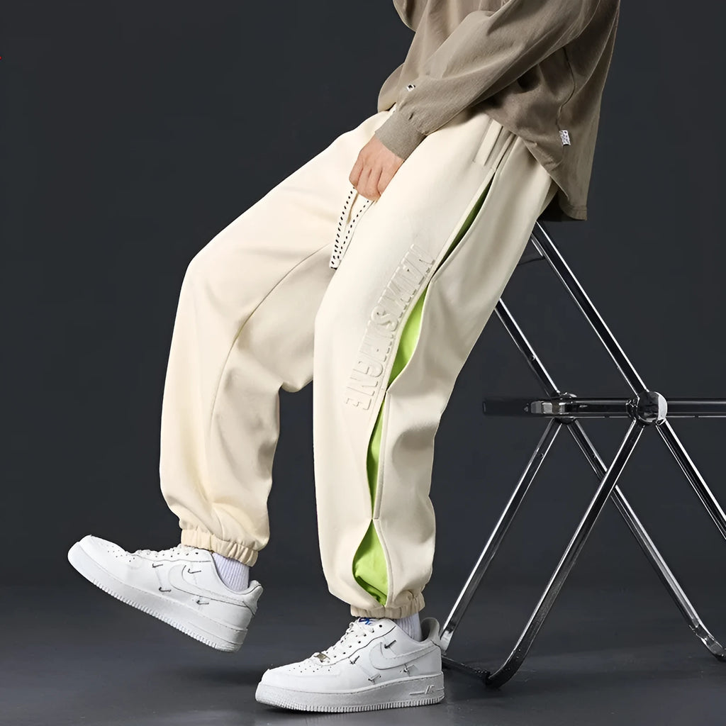 Men's loose fit cotton trousers with banded ankles and stitching details in grey green colour