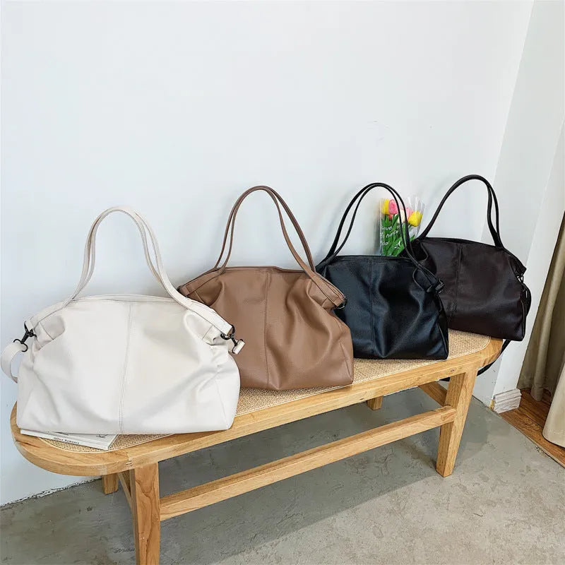 Large soft PU leather messenger bag in khaki colour with adjustable shoulder strap and top handle.
