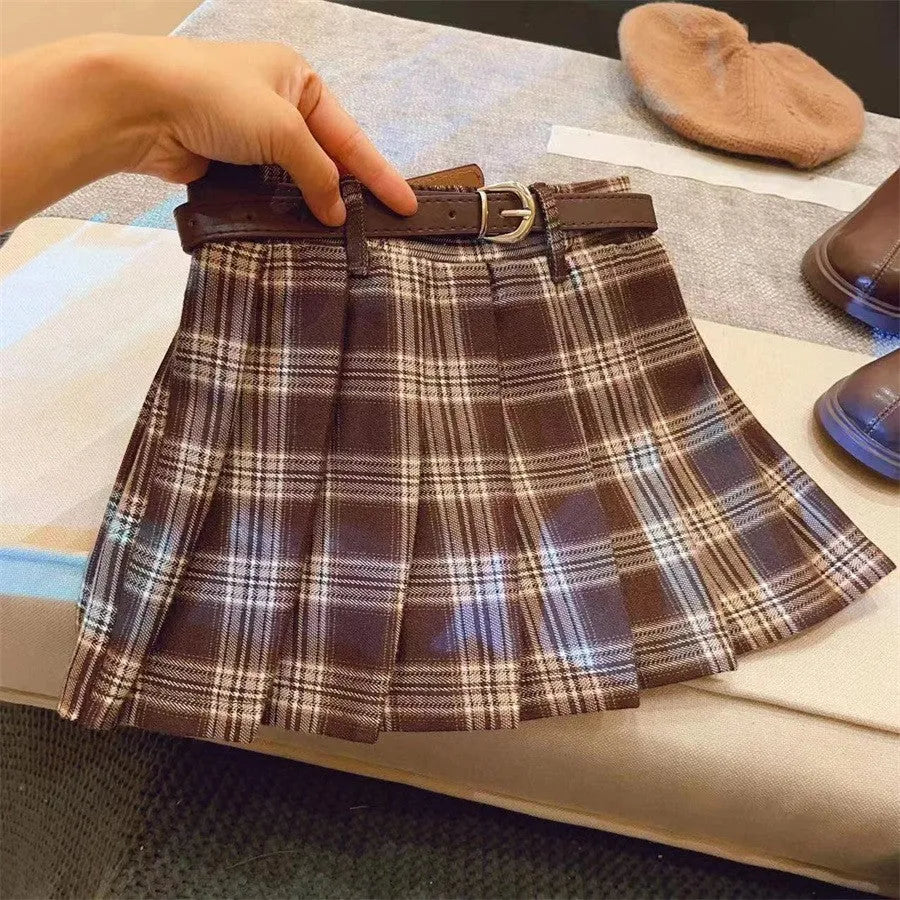 Girls red and black plaid pleated A-line skirt with a cotton lining, shown on a hanger.