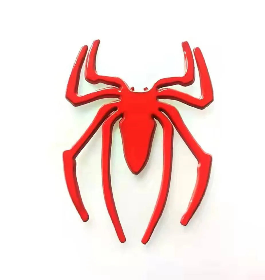Three-dimensional metal spider-shaped bumper sticker in silver finish on a white background.