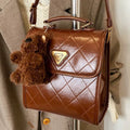 PU mini backpack in brown with stitching detail and pendant, front view